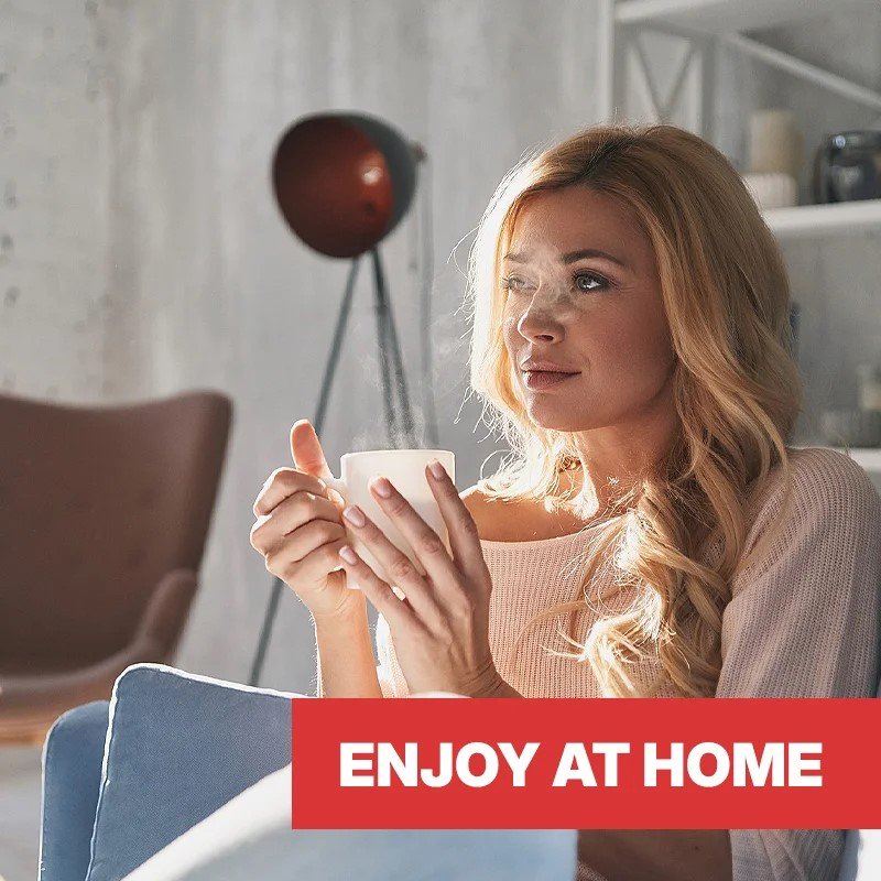 Lady sitting in a chair enjoying a cup of coffee at home